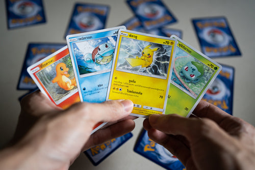 Hands holding a spread of Pokémon cards